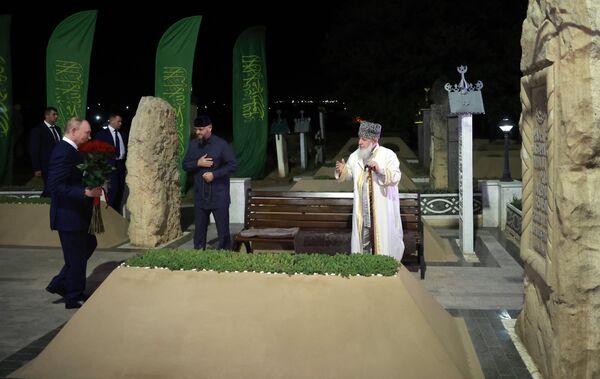 Vladimir Putin a bratranec Achmata Kadyrova, predseda Severokaukazskej federálnej rady Alim Khozh Achmat Kadyrov pri hrobke Achmata Chadžiho Kadyrova, prvého prezidenta ?e?enska a hrdinu Ruska, v dedine Achmat-Jurt. - Sputnik International