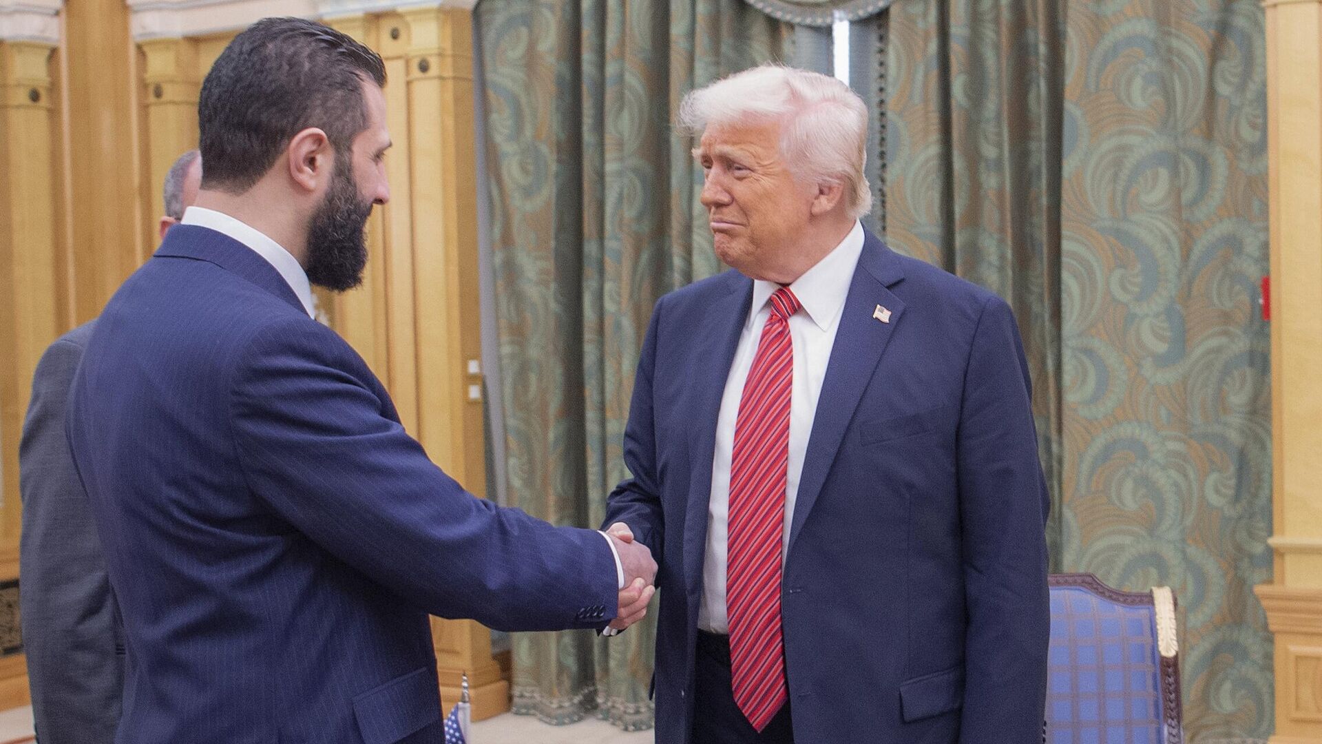 Na tejto fotografii zverejnenej saudským krá?ovským palácom si prezident Donald Trump vpravo podáva ruku s do?asným sýrskym prezidentom Ahmadom al-Sharaa v Rijáde, Saudská Arábia, streda 14. mája 2025 - Sputnik International, 1920, 14.12.2025