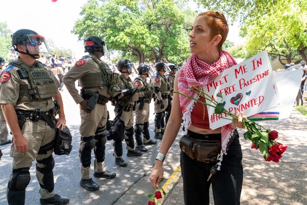 Demonštrant prechádza popri hliadke príslušníkov Texaského štátu na zhromaždení propalestínskych študentov na Texaskej univerzite v Austine v Texase (29. apríla 2024). Demonštrant prechádza popri hliadke príslušníkov Texaského štátu na zhromaždení propalestínskych študentov na Texaskej univerzite v Austine v Texase (29. apríla 2024). - Sputnik International
