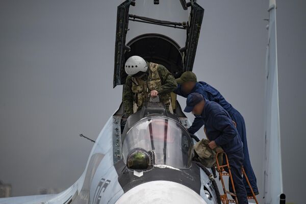 Technici a pilot viacúčelovej stíhačky Su-30SM ruských vzdušných síl na letisku stíhacej základne. Technici a pilot viacúčelovej stíhačky Su-30SM ruských vzdušných síl na letisku stíhacej základne. - Sputnik International