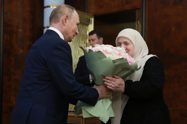 Vladimir Putin sa neformálne stretáva s matkou Ramzana Kadyrova Aimani Kadyrovovou a daruje jej kyticu kvetov. Vladimir Putin sa neformálne stretáva s matkou Ramzana Kadyrova Aimani Kadyrovovou a daruje jej kyticu kvetov. - Sputnik International