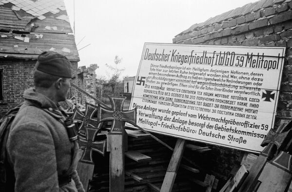Sovietsky vojak číta oznam od Nemcov, ktorý hovorí: „Tento cintorín je svätyňou tých národov, ktorých mŕtvi tu odpočívajú. Kto vykoná akékoľvek zmeny alebo dokonca poškodí hroby bez osobitného pokynu, bude za ich poškodenie prísne potrestaný. Rodičia sú zodpovední za činy svojich detí. Sovietsky vojak číta oznam od Nemcov, ktorý hovorí: „Tento cintorín je svätyňou tých národov, ktorých mŕtvi tu odpočívajú. Kto vykoná akékoľvek zmeny alebo dokonca poškodí hroby bez osobitného pokynu, bude za ich poškodenie prísne potrestaný. Rodičia sú zodpovední za činy svojich detí.