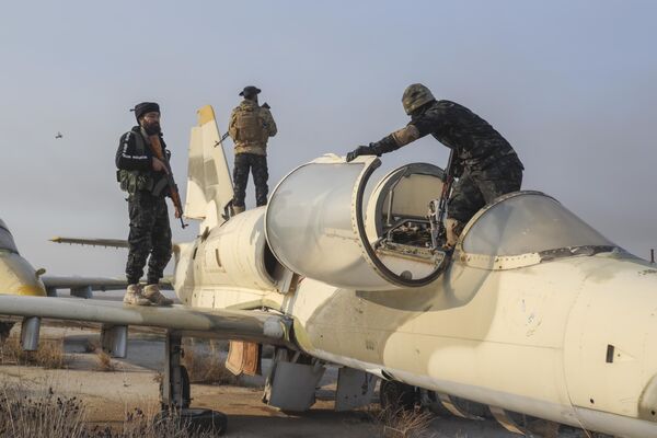 Bojovníci Tahrir al-Sham stoja v lietadle na vojenskom letisku Al-Nayrab po tom, čo sa zmocnili kontroly nad zariadením nachádzajúcim sa na okraji Aleppa. Bojovníci Tahrir al-Sham stoja v lietadle na vojenskom letisku Al-Nayrab po tom, čo sa zmocnili kontroly nad zariadením nachádzajúcim sa na okraji Aleppa. - Sputnik International